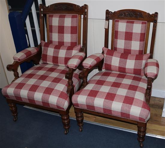 A pair of Victorian walnut upholstered elbow chairs